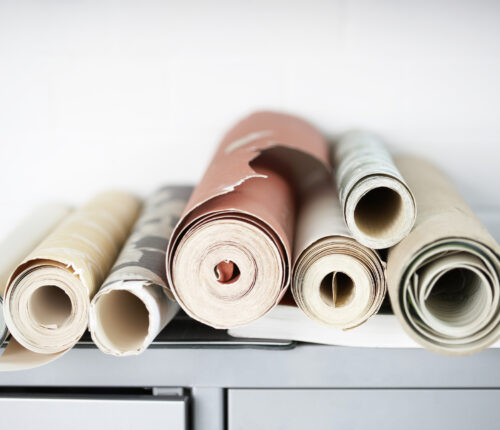 A stack of wall paper rolls on a counter.